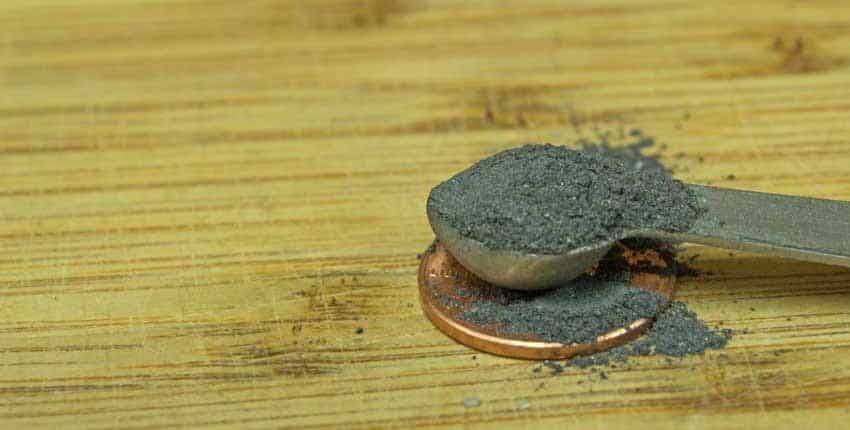 A penny sitting on top of a wooden floor.