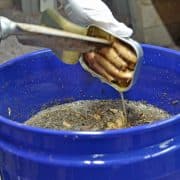 A person is using tongs to stir something in a bowl.