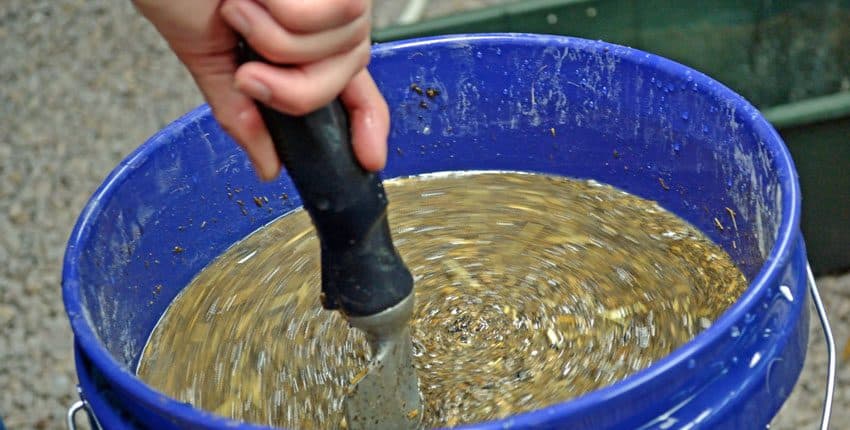 A person using a knife to cut through the contents of a bowl.