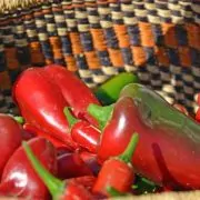 A basket of red peppers and green bell peppers.