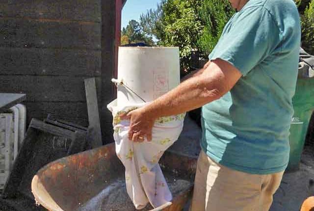 A man is washing his toilet outside