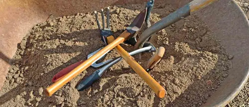 A bunch of tools sitting in the dirt.