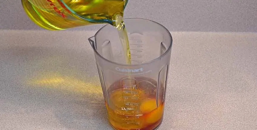 A glass of orange juice being poured into it.