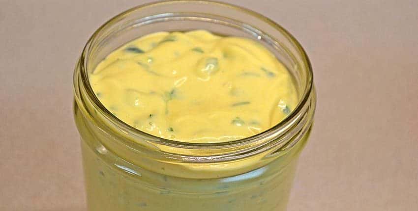 A jar of yellow liquid on top of a table.