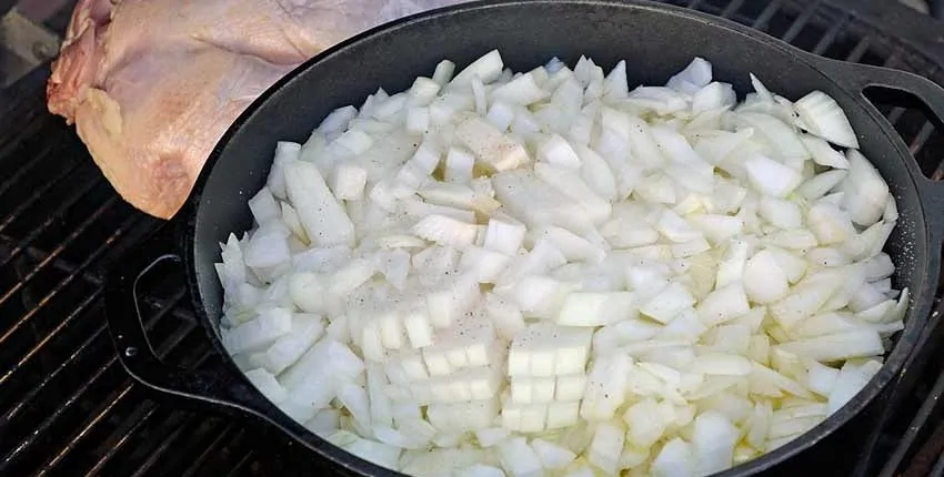 A pan of onions is cooking on the stove.