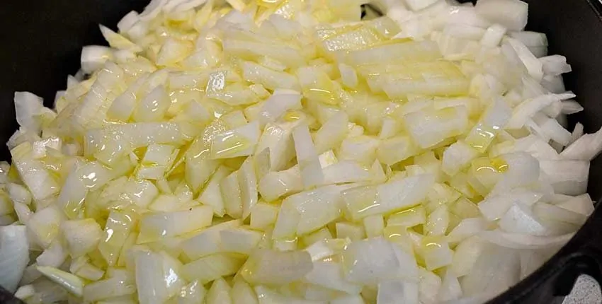 A close up of chopped onions on top of a pan.