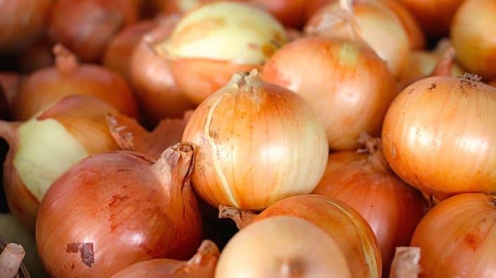 A close up of onions in the middle of a pile