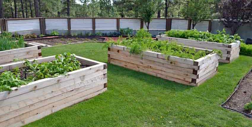 A garden with many wooden raised beds in the middle of it.