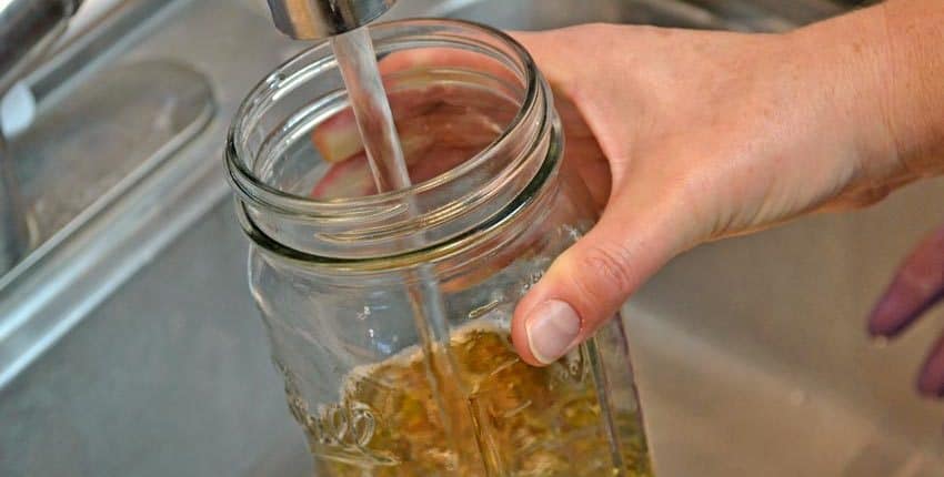 A person holding onto the lid of a jar