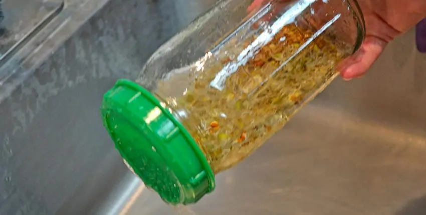 A person is holding onto the lid of a jar.