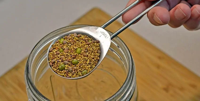 A person is holding a spoon over some food.