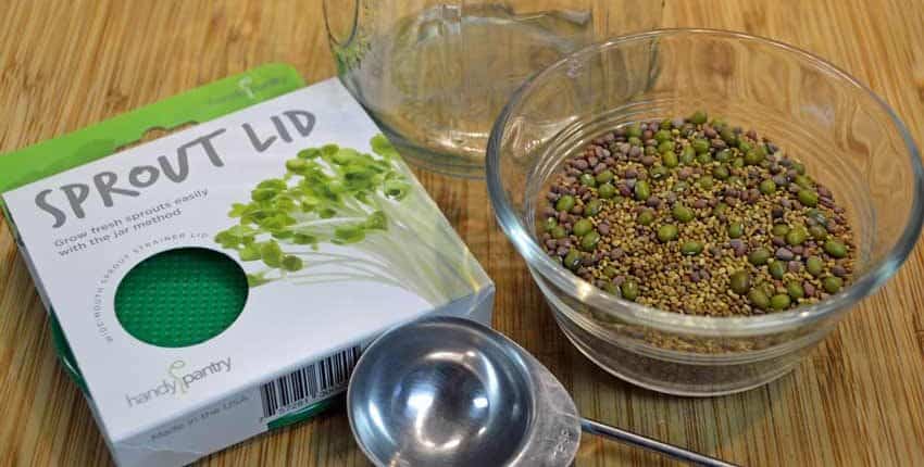 A box of green lentils next to a bowl and measuring spoons.