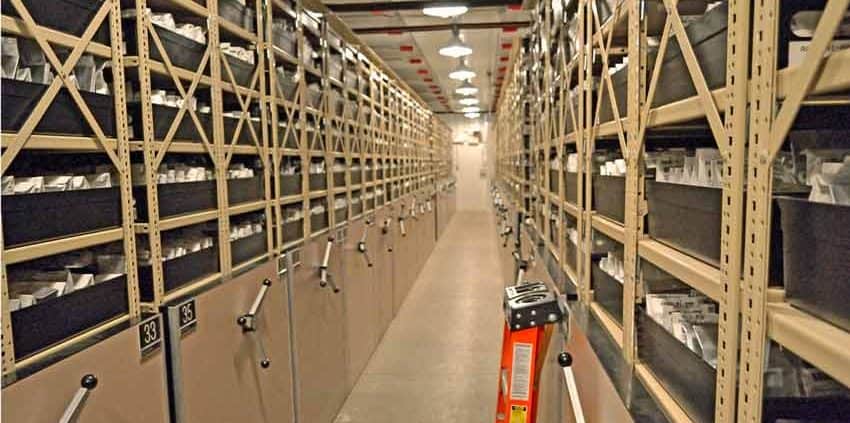 A long hallway with many shelves of books.