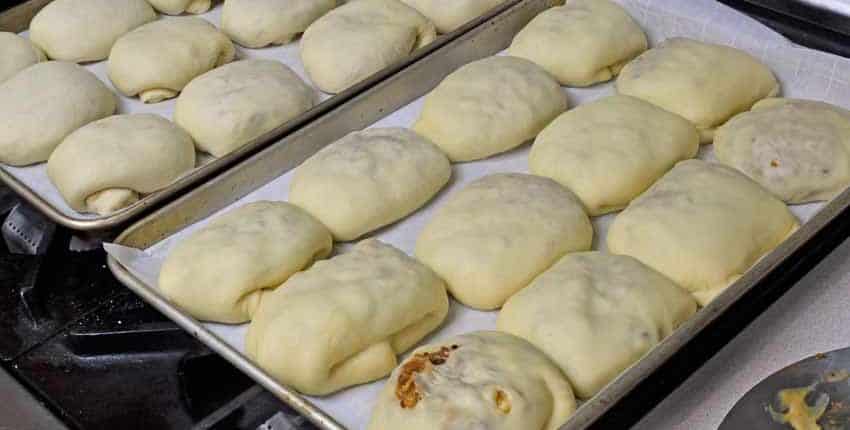 A tray of bread rolls sitting on top of a table.