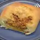 A piece of bread with meat on it.
