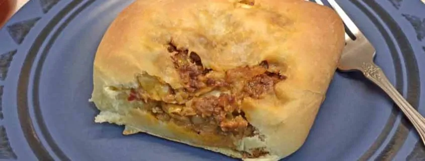 A piece of bread with meat on it.