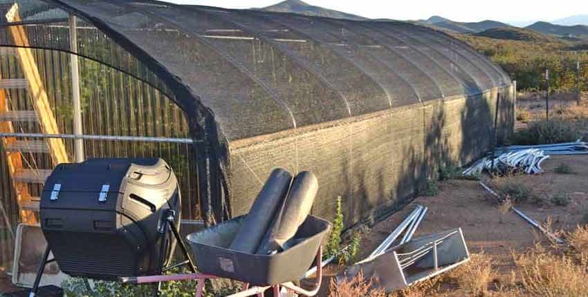 A large building with a metal fence and some chairs.