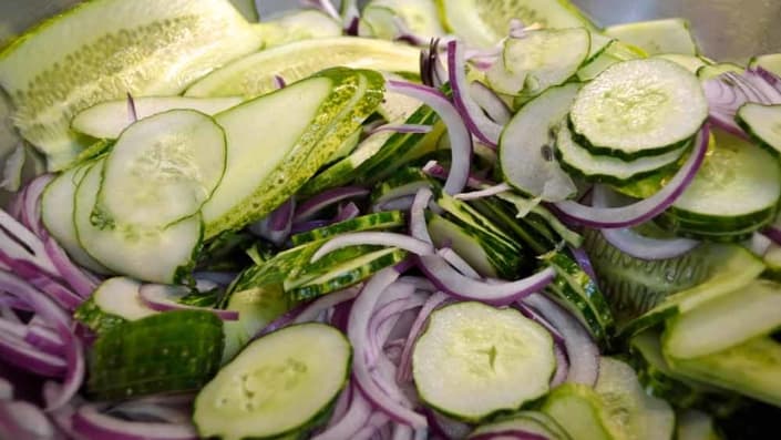 A close up of some cucumbers and onions