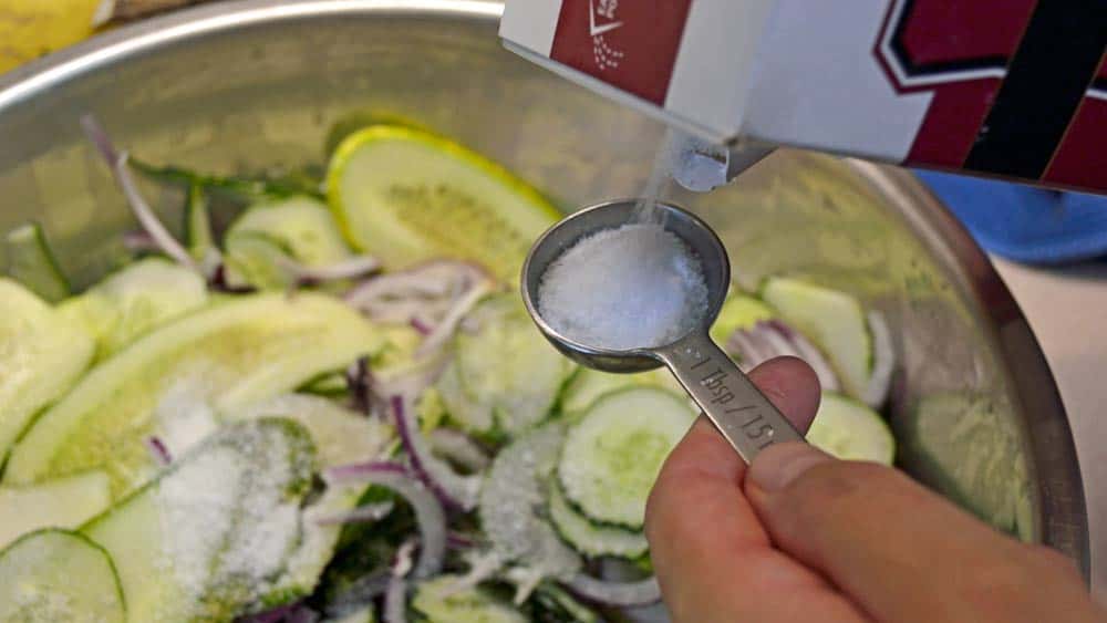 A person holding a spoon over some food.