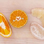 A close up of an orange and some other fruit