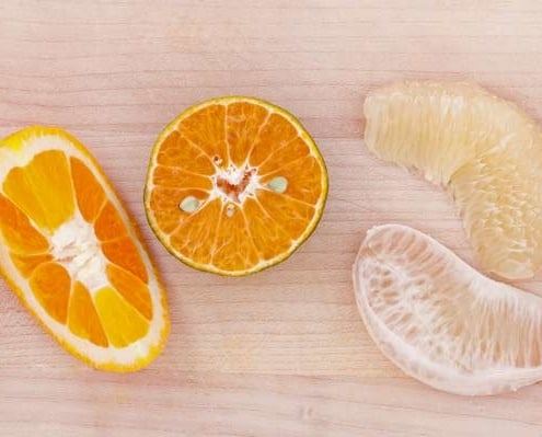 A close up of an orange and some other fruit