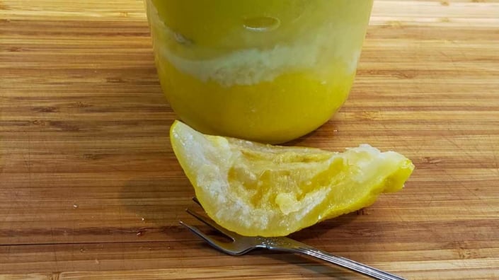 A close up of an orange and a spoon